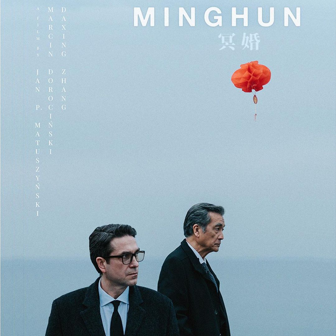Plakat do filmu Minghun. Na tle morza o&nbsp;szaroniebieskiej barwie znajduje się dwóch mężczyzn w&nbsp;ciemnych garniturach. Ten na pierwszym planie stoi przodem do widza, ten na drugim - widoczny jest z&nbsp;prawego profilu. Nad ich głową unosi się przyczepiony do niewidocznej na zdjęciu konstrukcji czerwony chiński lampion.
